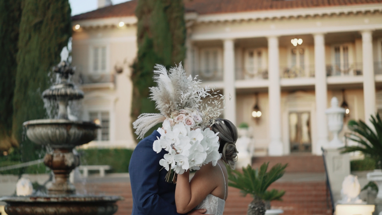 Bride & Groom hiding a kiss under bouquet